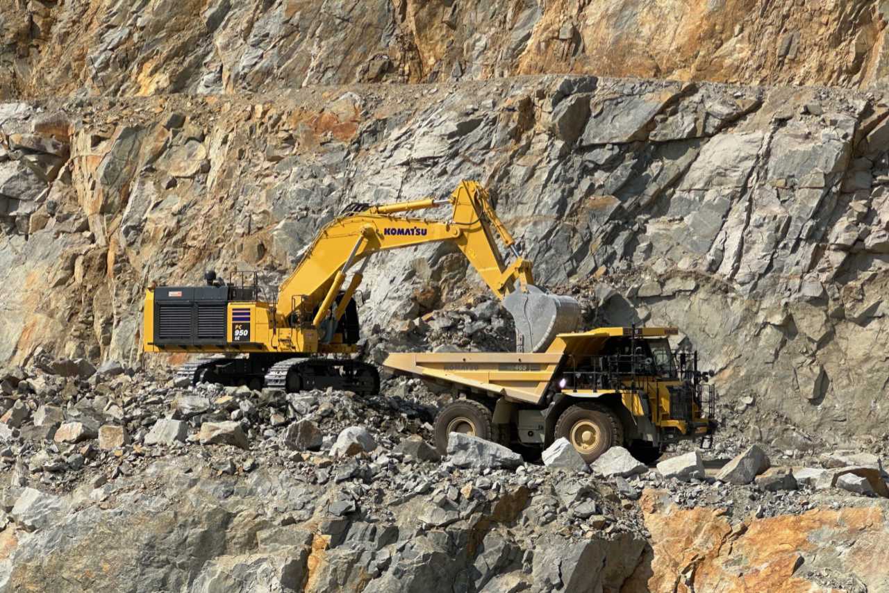 Bagger und Mulde im Steinbruch bei der Arbeit